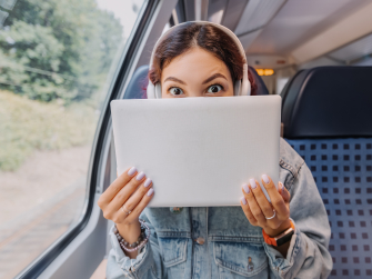 Frau versteckt sich Hinter Laptop in der Bahn
