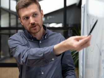 Schulung_Mensch erklärt etwas an einem Whiteboard