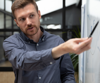 Schulung_Mensch erklärt etwas an einem Whiteboard